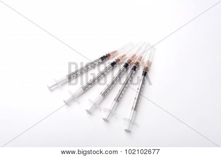 Top View Of The Five Disposable Syringes On The White Background