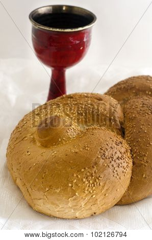 Challah and Wine on white tablecloth for the Jewish weekly ceremonial friday meal to welcome in shabbat.