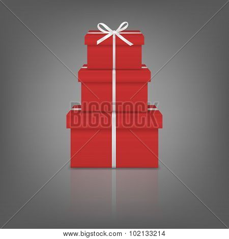 Stack of three realistic red gift boxes with white ribbon and bow