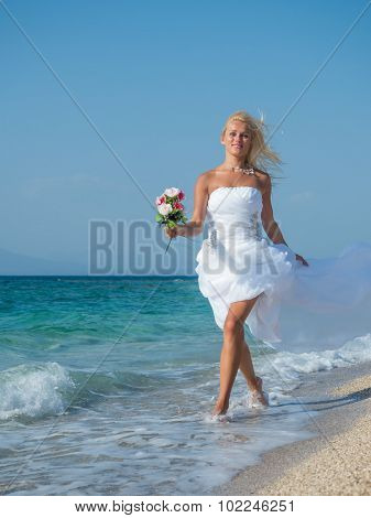 Young bride in white wedding dress  on the beach in Greece