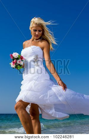 Young bride in white wedding dress  on the beach in Greece