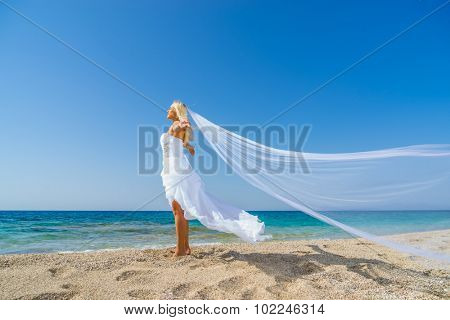 Young bride in white wedding dress  on the beach in Greece