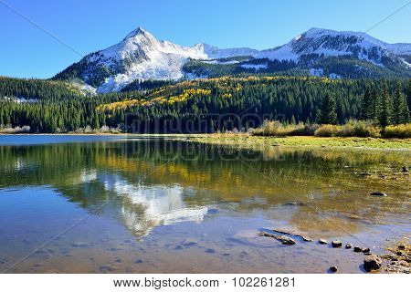 Alpine Scenery Of Yellow And Green Aspen, Snow Covered Mountains And Reflection In The Lake During F