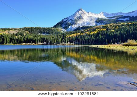 Alpine Scenery Of Yellow And Green Aspen, Snow Covered Mountains And Reflection In The Lake During F