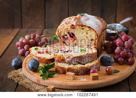 Juicy and tender cupcake with plums and grapes