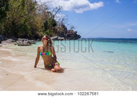 Young woman reaxing on the beach at exotic resort