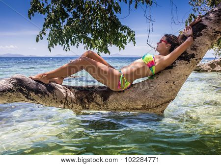 Young woman reaxing on the beach at exotic resort