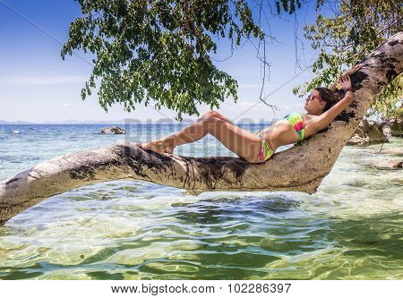 Young woman reaxing on the beach at exotic resort