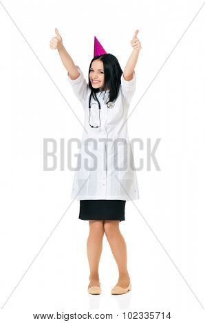 Cheerful young female doctor wearing birthday cap, isolated white background