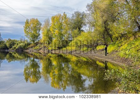 Autumn landscape on the river with fishermen