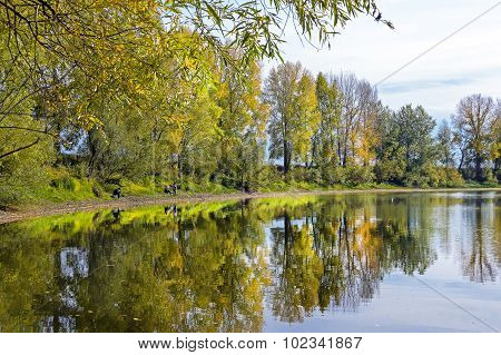 Autumn landscape on the river with fishermen
