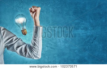 Hand of business person showing power concept  and glowing light bulb