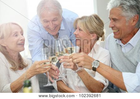 Group of senior people celebrating with champagne