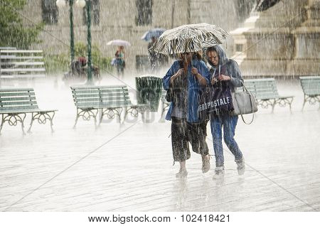 Two Women Walking under Umbrella during Heavy Rain