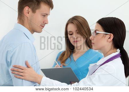 Friendly Female Doctor Touching Male Patient's Arm For Encouragement And Empathy