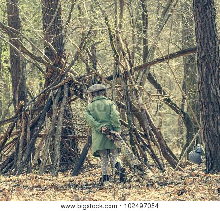 ittle cute girl builds a hut in the woods. back view. Photo in retro style