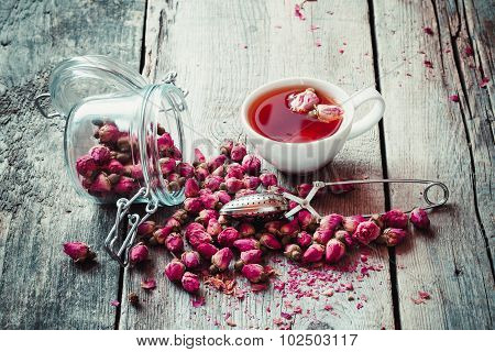 Dry Rose Buds, Tea Cup, Strainer And Glass Jar With Rosebuds. Selective Focus.