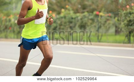 Marathon runner legs running on city road
