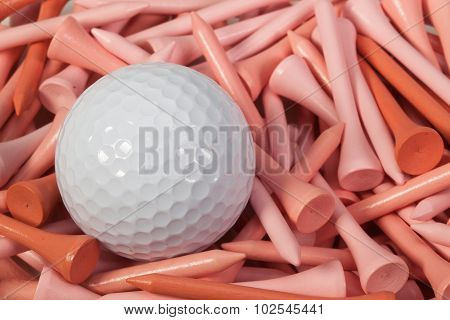 White Golf Ball Lying Between Wooden Tees