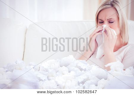 Woman blowing her nose against used tissues