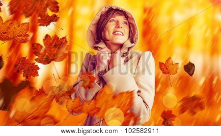 Smiling beautiful woman in winter coat looking up against view of a forest in the mist