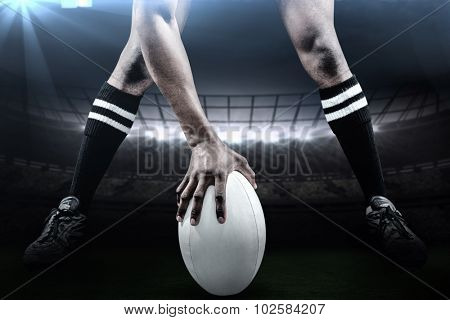 Low section of sportsman playing rugby against rugby stadium