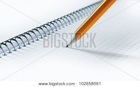 Yellow pancil on blank notebook with spiral