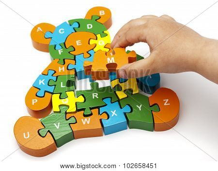 solving bear puzzle letters with child's hand copy