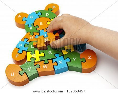 solving bear puzzle letters with child's hand copy