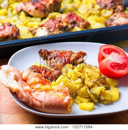 Plate Of Chicken And Potatoes Baked On A Grill