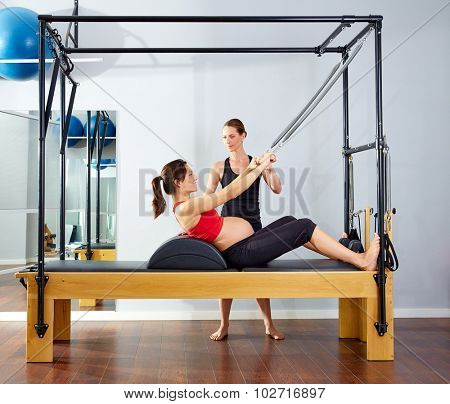 pregnant woman pilates reformer roll up cadillac exercise with personal trainer