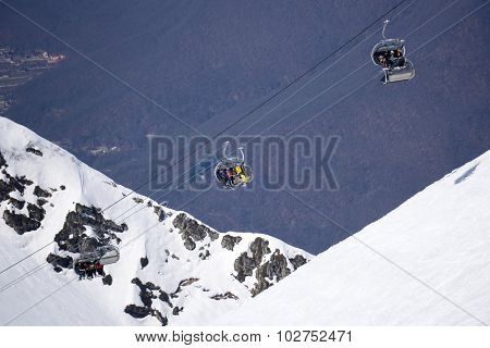 Skiers and snowboarders on a mountain ski lift