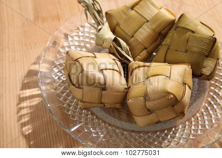 Ketupat (Rice Dumpling) On wooden Background. Ketupat is a natural rice casing made from young coconut leaves for cooking rice during eid Mubarak