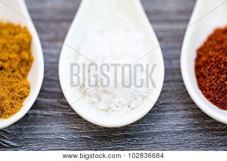 close up of three ceramic spoons with colorful spices