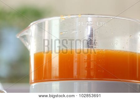 Fresh Orange Juice In Juicer Machine With Hand