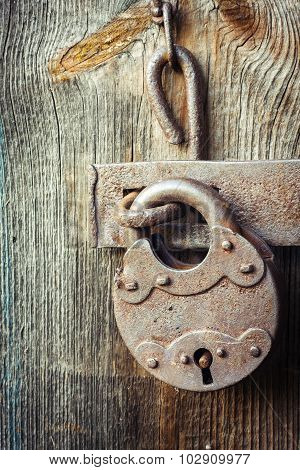 Old rusty padlock on wooden background