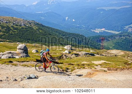 Unidentified biker climbs the hill in Bucegi Mountains in Romania