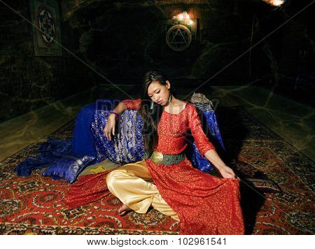 young pretty asian girl in bright colored interior on carpet