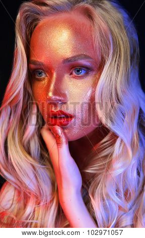 Beautyful girl with gold glitter on her face