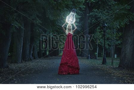 Art photo - stunning blonde beauty hodling a big lightbulb