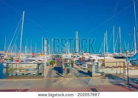 PALMA DE MALLORCA, SPAIN - AUGUST 18 2017: Unidentified people walking at harbor with white yachts in the water, in Palma de Mallorca, Balearic islands, Spain.