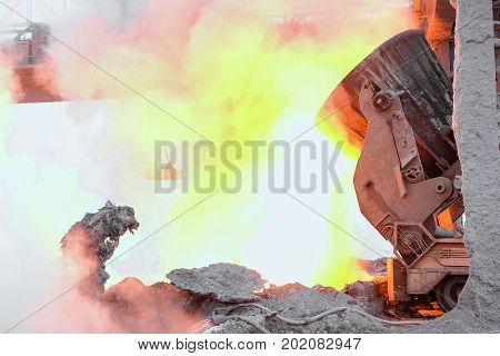 Bright hot industrial metallurgical shop. Transporter tipper with a metal ladlel for transporting and pouring melt. Heavy industry background.