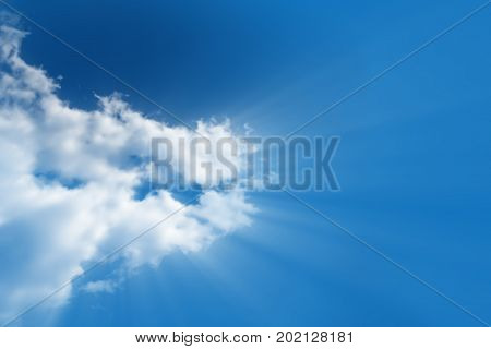 A bright white cloud from which the divine light rays flows in a clear bright blue sky