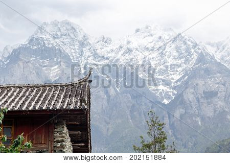 Beautiful view on traditional house' roof on against covered mountains in Shangri-La
