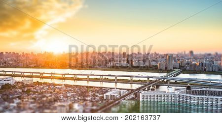 Business and culture concept - panoramic modern city skyline bird eye aerial view under dramatic sunset glow and beautiful cloudy sky in Tokyo Japan. Miniature Tilt-shift effect