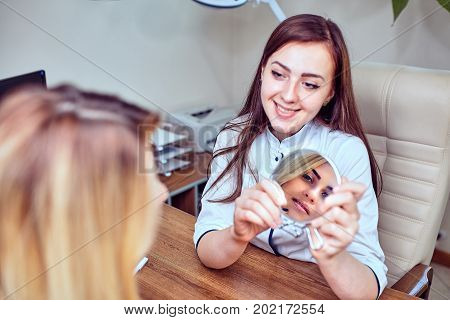 Smiling visitor listening beautician in medicine center
