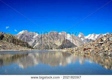 lake and waterfall in forest, mountains of Caucasus, Russia.