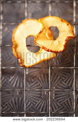 Dried apple slices hanging on string with dark metal backdrop