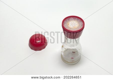 Empty Glass Pepper Mill With Two Degrees Of Grind, With The Red Cover, Laying Nearby