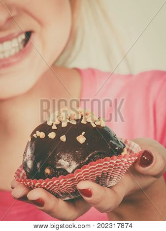 Woman Holding Chocolate Cupcake About To Bite